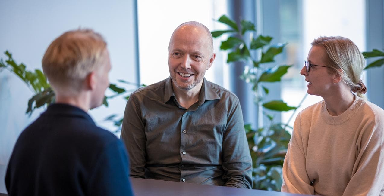 3 ansatte i Sikt sitter rundt et bord